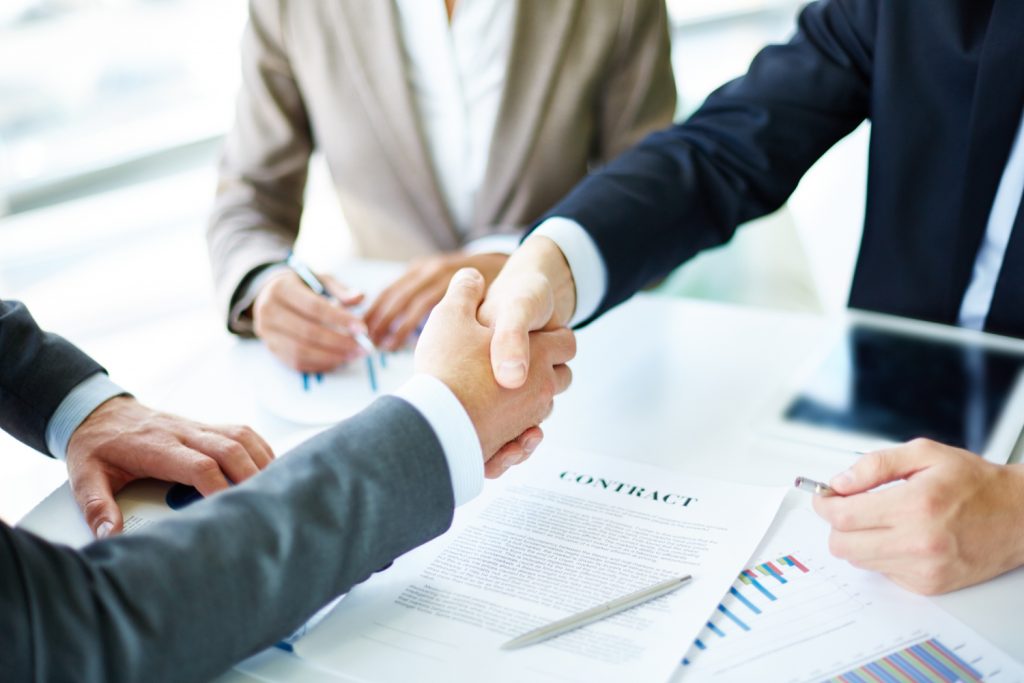 Fraude en contratos menores - apretón de manos sobre contrato